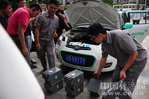 力帆汽車研發生產的電動汽車，工作人員正在為車輛替換電源。