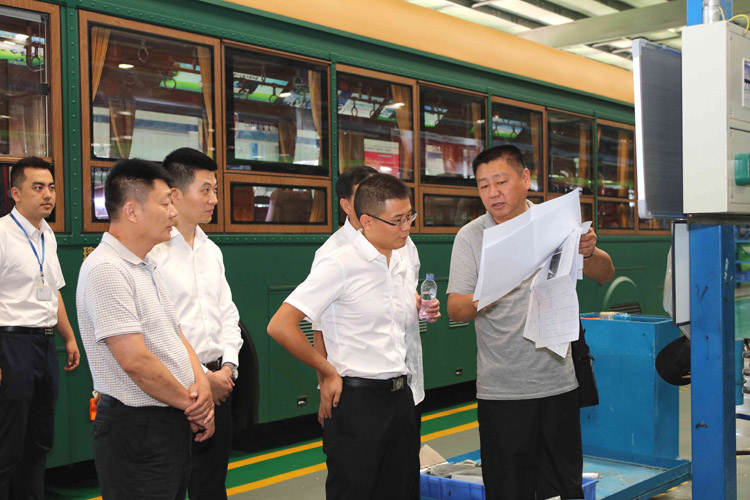 新能源汽車生產(chǎn)現(xiàn)場，領(lǐng)導(dǎo)們對汽車性能與參數(shù)作深入咨詢